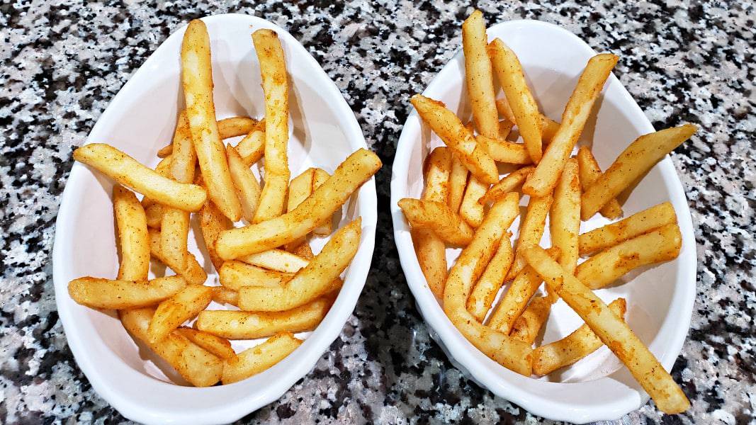 crispy seasoned fries in two baking dishes.