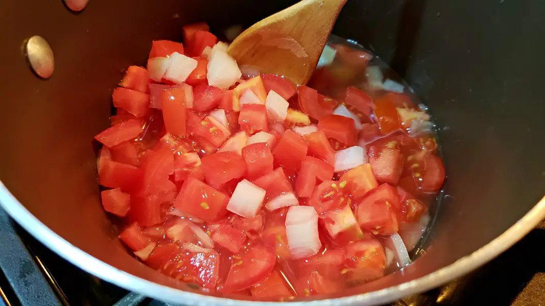 diced tomatoes, onions, and garlic cooking in chicken broth.