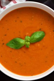 Garden Fresh Tomato Soup in a bowl with fresh basil on top.