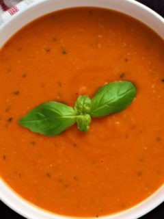 Garden Fresh Tomato Soup in a bowl with fresh basil on top.
