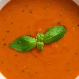 Garden Fresh Tomato Soup in a bowl with fresh basil on top.