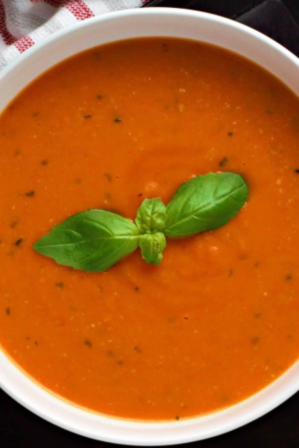 Garden Fresh Tomato Soup in a bowl with fresh basil on top.