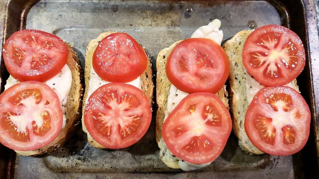 toast and chicken topped with tomatoes.