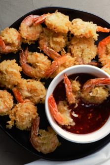 Beer Battered Coconut Shrimp on a plate with a bowl of dipping sauce.