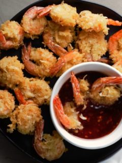 Beer Battered Coconut Shrimp on a plate with a bowl of dipping sauce.