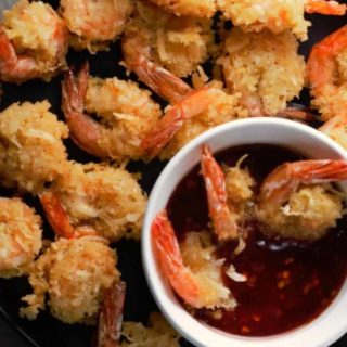 Beer Battered Coconut Shrimp on a plate with a bowl of dipping sauce.