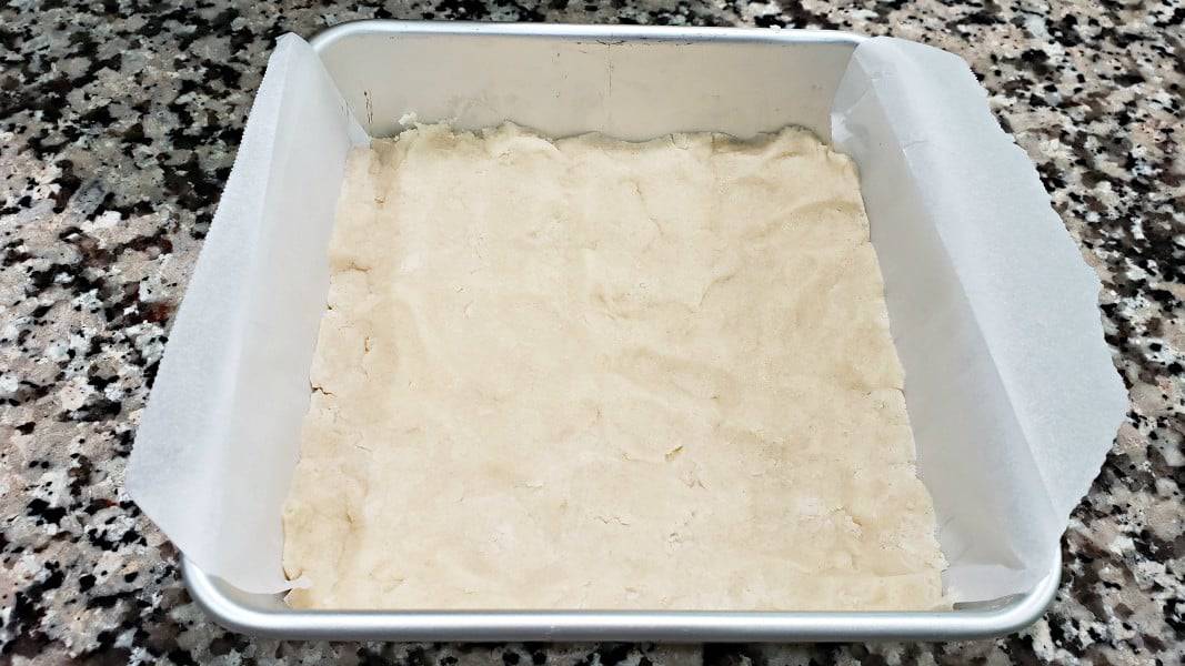 shortbread crust dough pressed into a cake pan