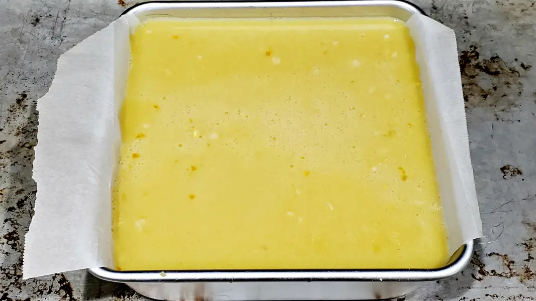 lemon bar filling poured into cake pan.
