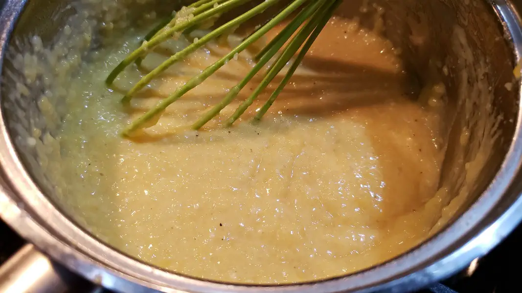 cheddar polenta cooking in a pan.