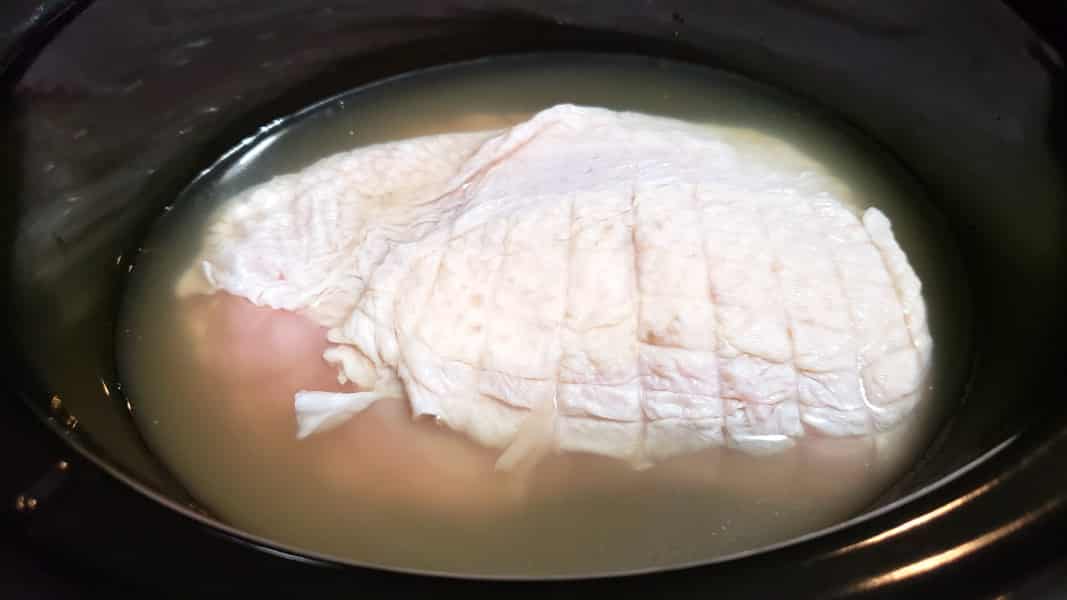 boneless turkey breast and broth in a crockpot.