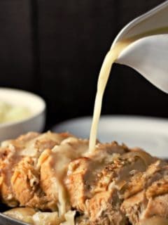 Turkey Breast on a plate with Gravy pouring onto it.