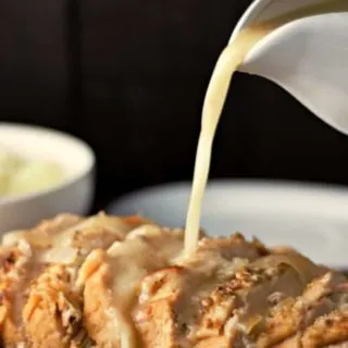 Turkey Breast on a plate with Gravy pouring onto it.