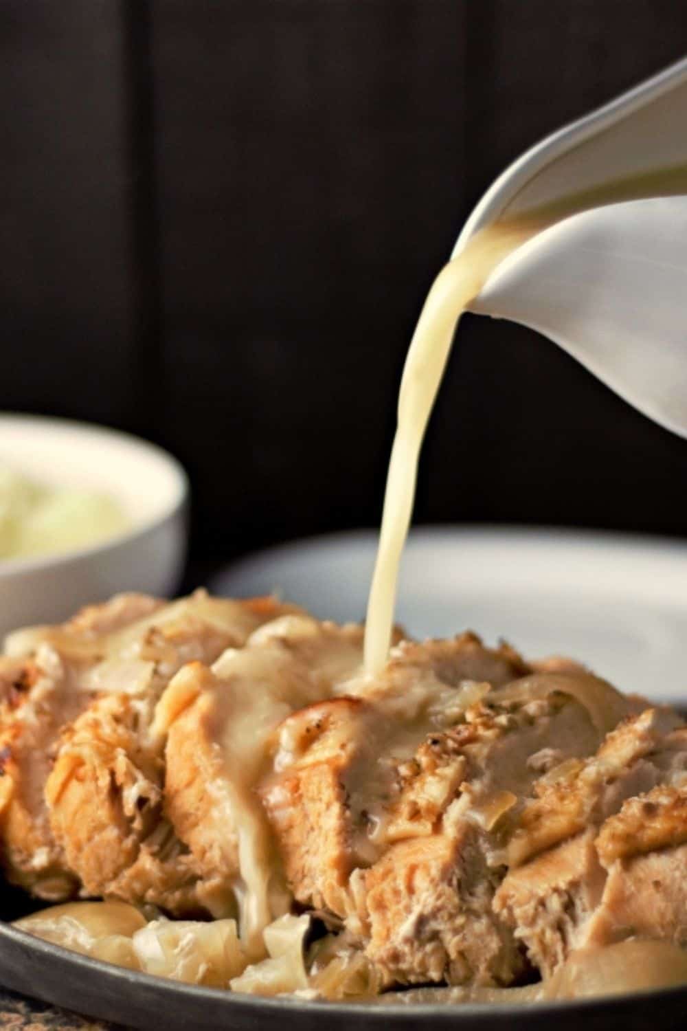 Turkey Breast on a plate with Gravy pouring onto it.