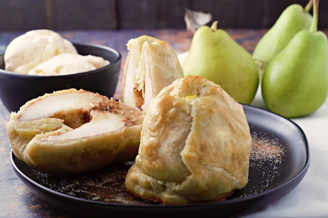 Puff Pastry Cinnamon Baked Pears Dessert on a plate with one cut open.