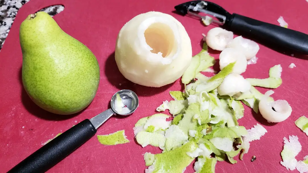 two pears, one is peeled and cored.
