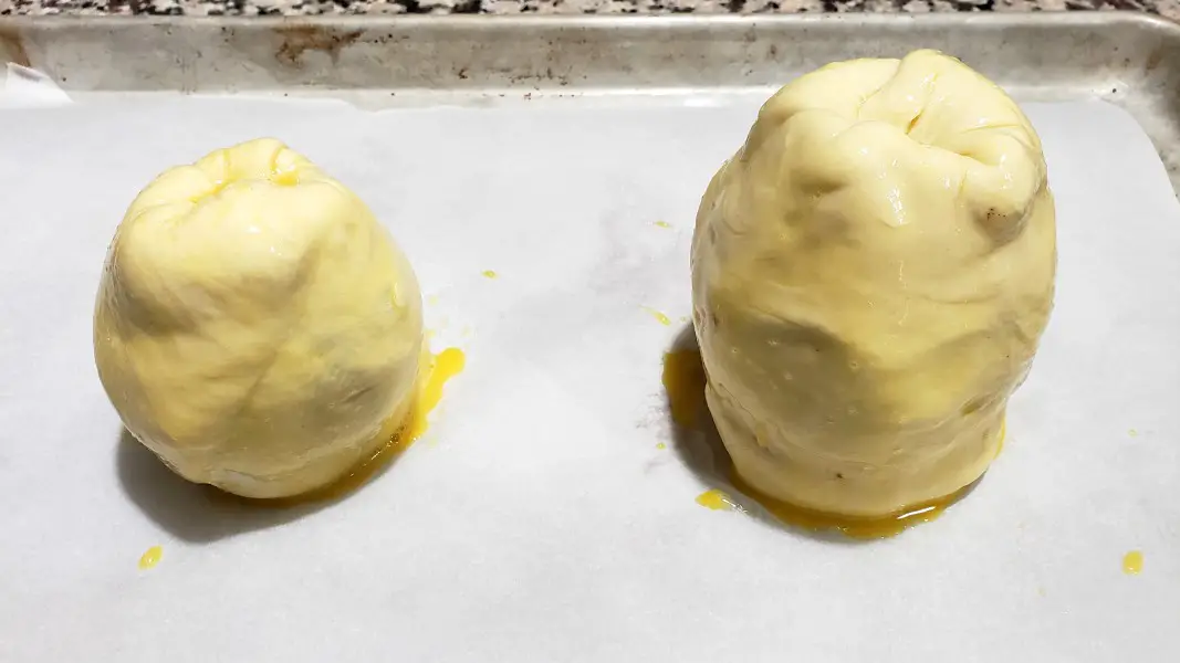 two pears wrapped in puff pastry and brushed with egg wash.