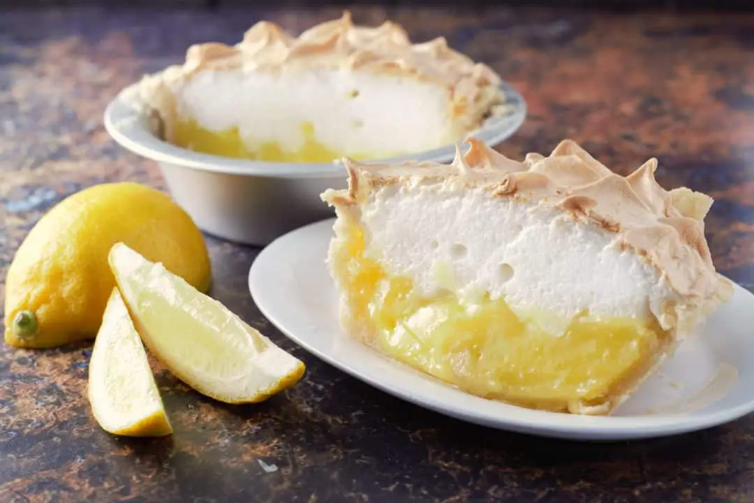 a piece of Small Batch Lemon Meringue Pie on a plate and a piece in a pie pan.