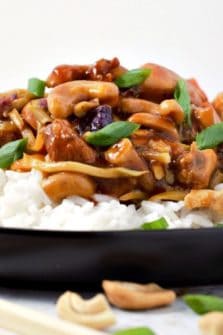 Cashew Chicken over rice on a plate.