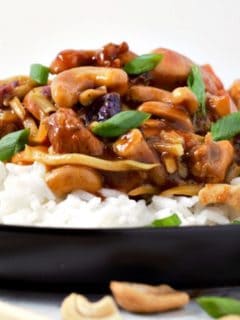 Cashew Chicken over rice on a plate.
