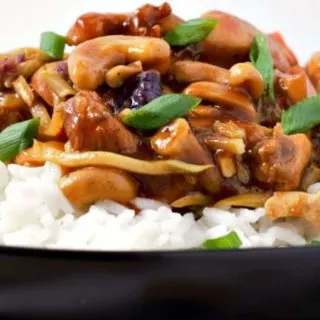 Cashew Chicken over rice on a plate.