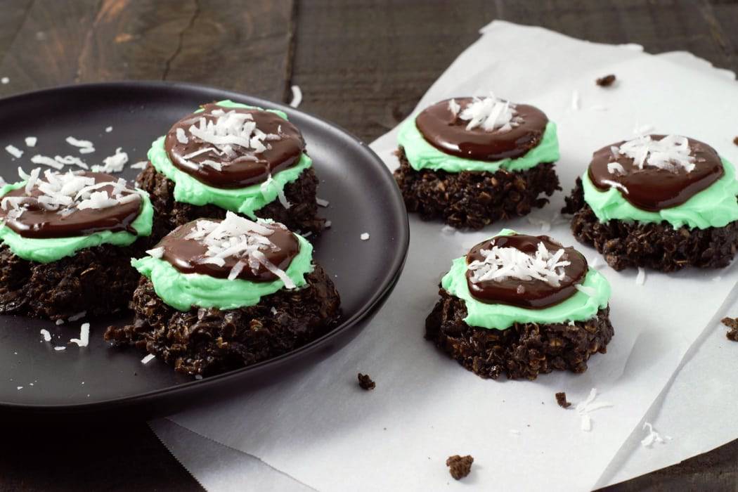 six Chocolate No Bake Cookies with Mint and Coconut, three on a plate, three on parchment paper