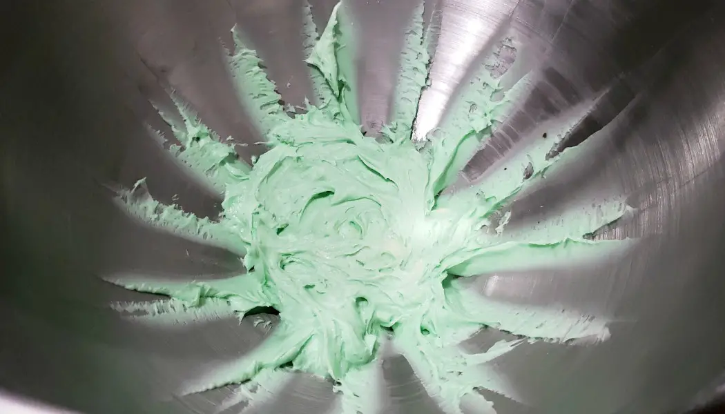 green mint frosting in a mixing bowl