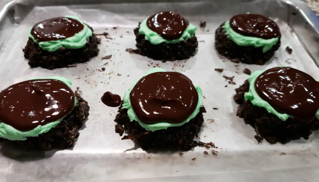 6 no bake cookies with green mint frosting and chocolate ganache on top