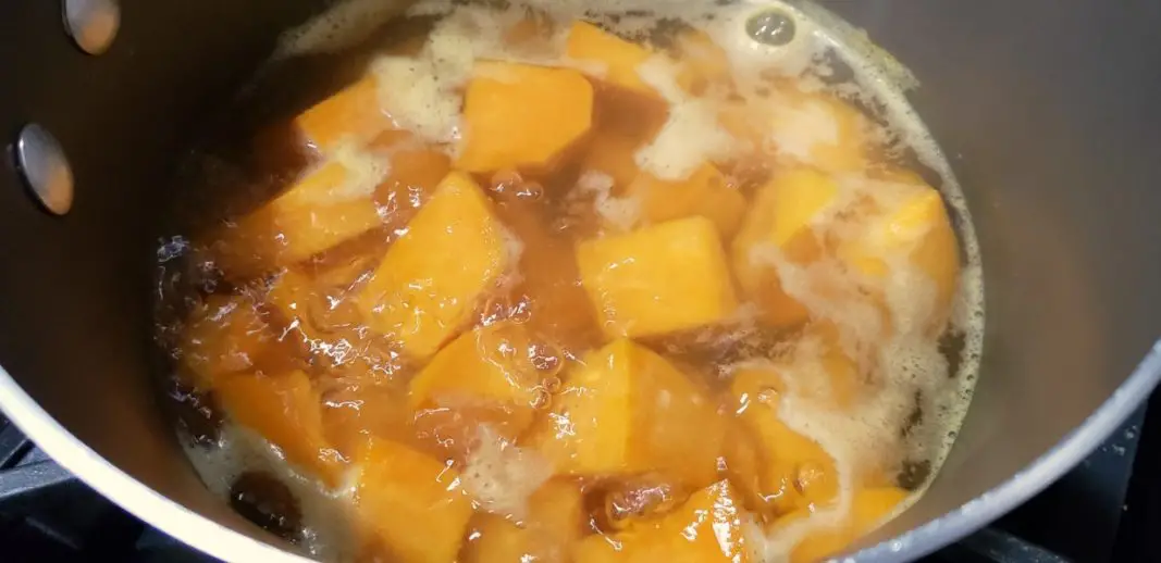 cubed sweet potatoes cooking in a pan.