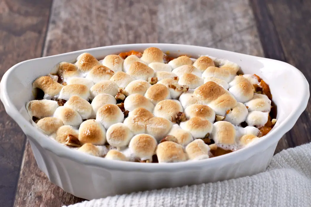 Sweet Potato Casserole with Pecans and Marshmallows baked in a dish.