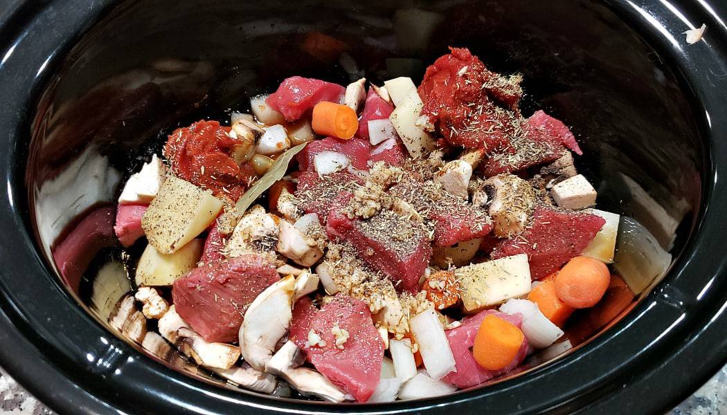 stew meat, veggies, and seasonings in a crockpot slow cooker
