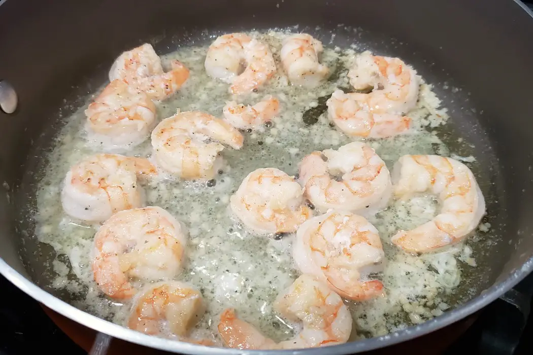 shrimp, garlic, salt, and pepper frying in a pan
