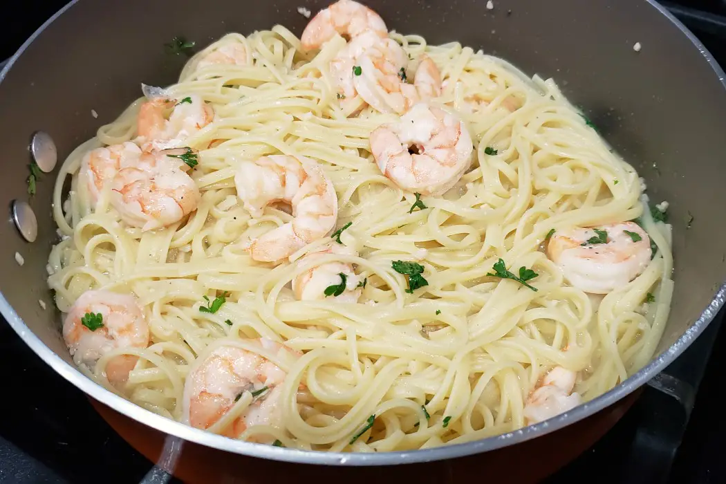 linguine pasta added to the pan with the shrimp scampi