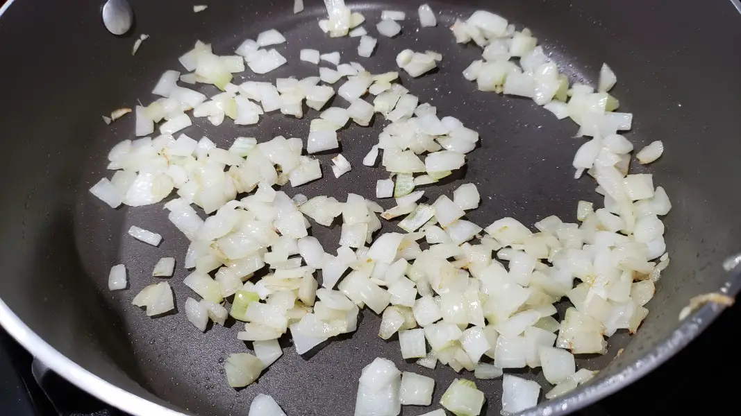 diced onion cooking in a frying pan