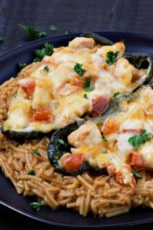 Chicken Cheese Stuffed Poblano Peppers over rice on a plate.