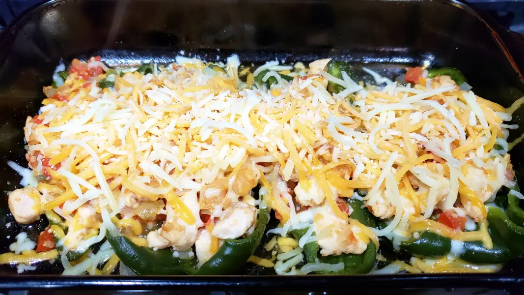 chicken and cheese stuffed poblano peppers in a casserole dish
