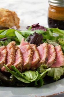 Sesame Seed Tuna Steak Salad on a plate with Asian Ginger Dressing.