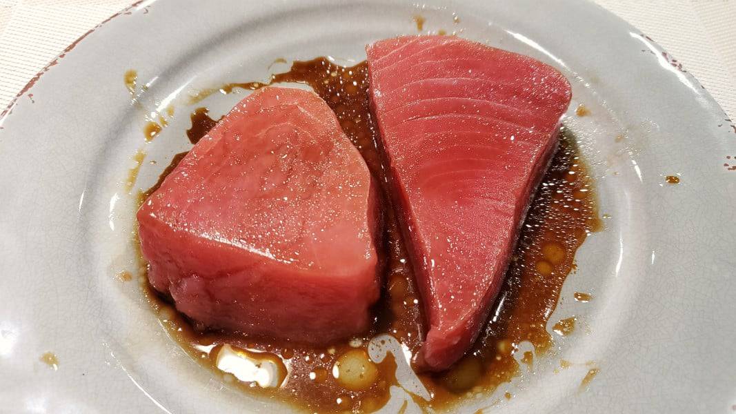 two raw tuna steaks covered in soy sauce mixture