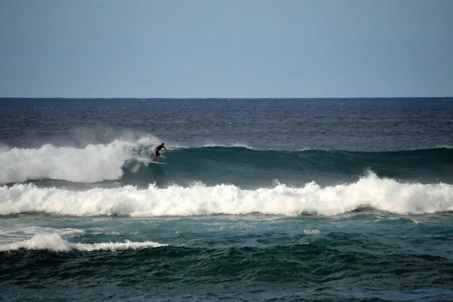 a surfer riding a wave at Ho'okipa beach park