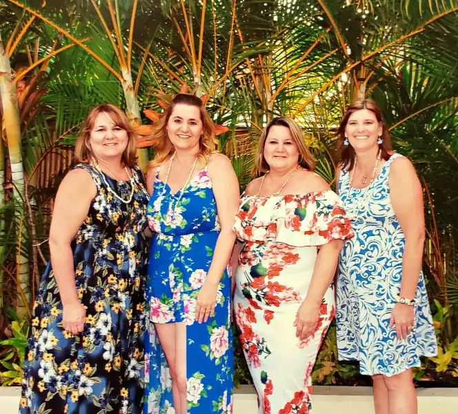 4 women dressed in Hawaiian print dresses