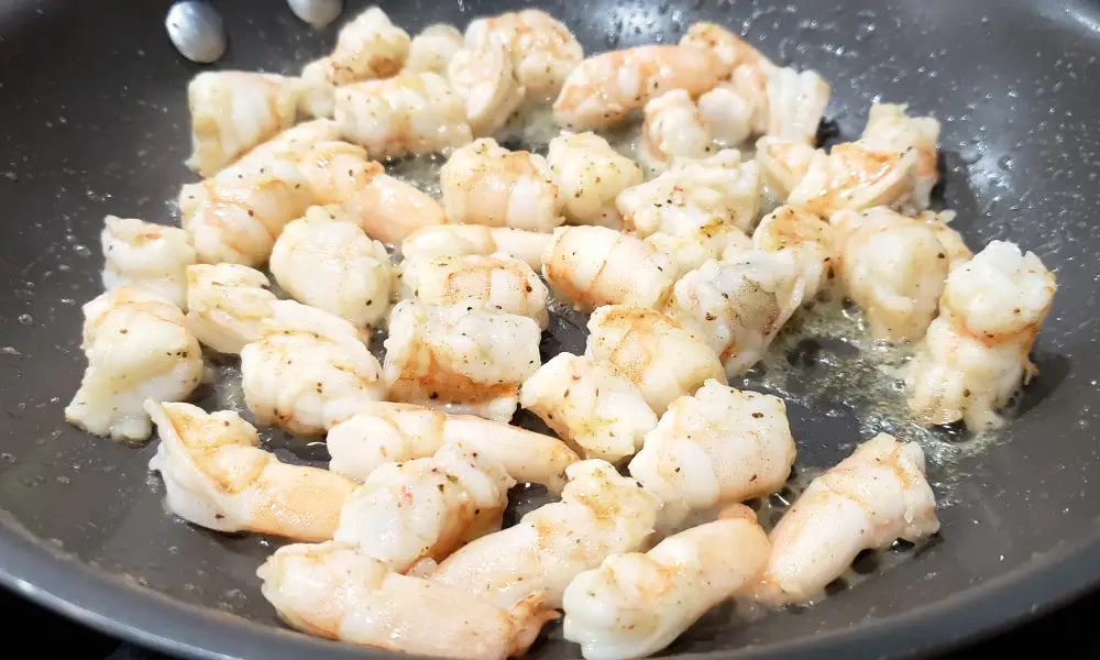 seasoned shrimp cooking in a pan