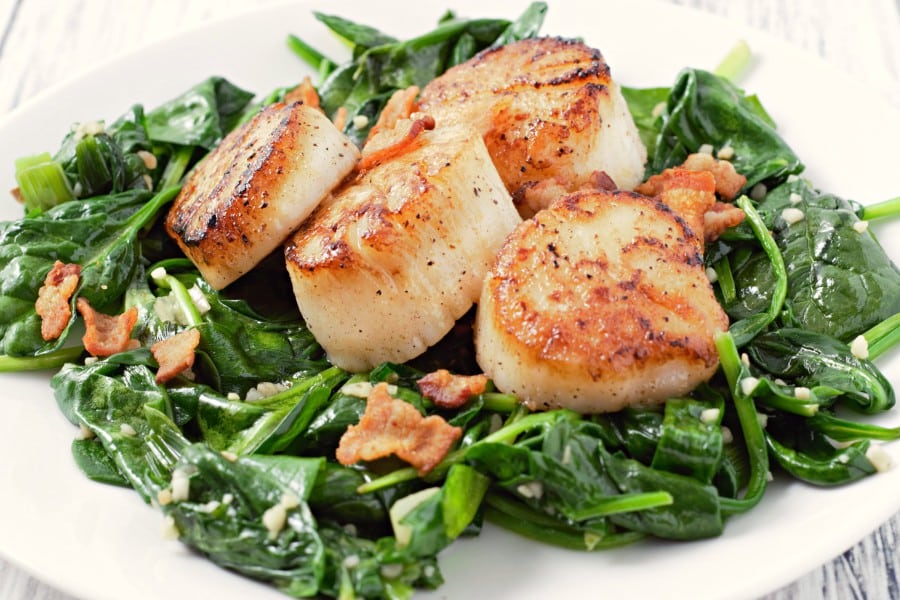 Pan Seared Scallops with Bacon and Spinach on a plate