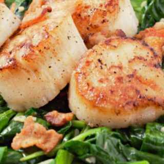 Seared Scallops with Spinach and Bacon on a plate.