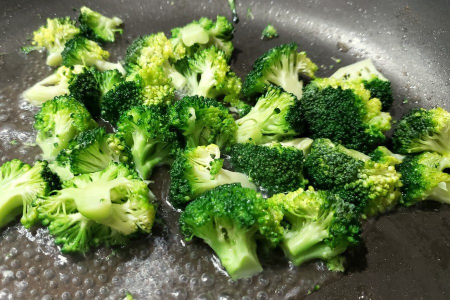 broccoli florets cooking in a pan