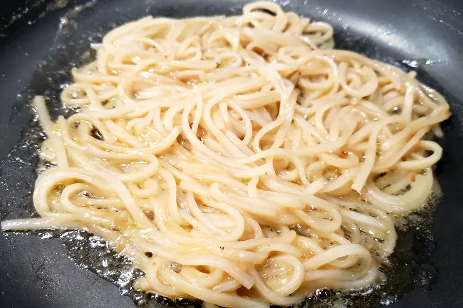 Pad Thai rice noodles and sauce cooking in a pan