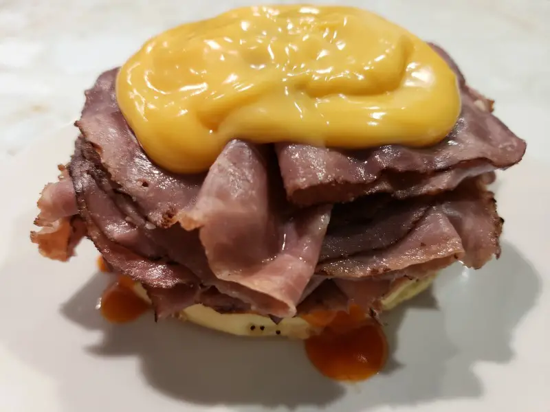 a bottom half of a beef and cheddar sandwich