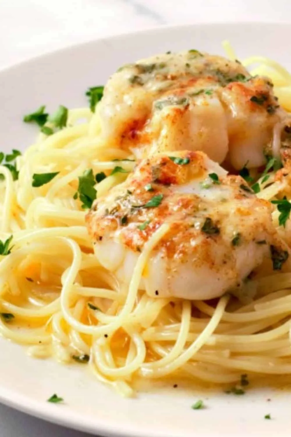 Baked Buttery Sea Scallops with Pasta on a plate.