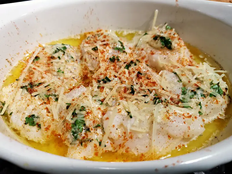 Baked Buttery Parmesan Scallops in a casserole dish ready to broil