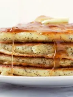 Lemon Poppy Seed Pancakes in a stack on a plate.