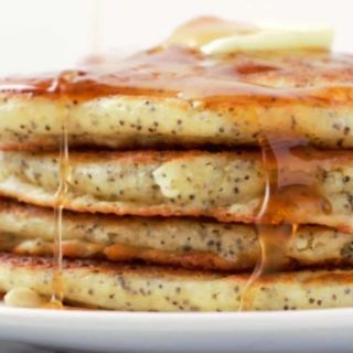 Lemon Poppy Seed Pancakes in a stack on a plate.