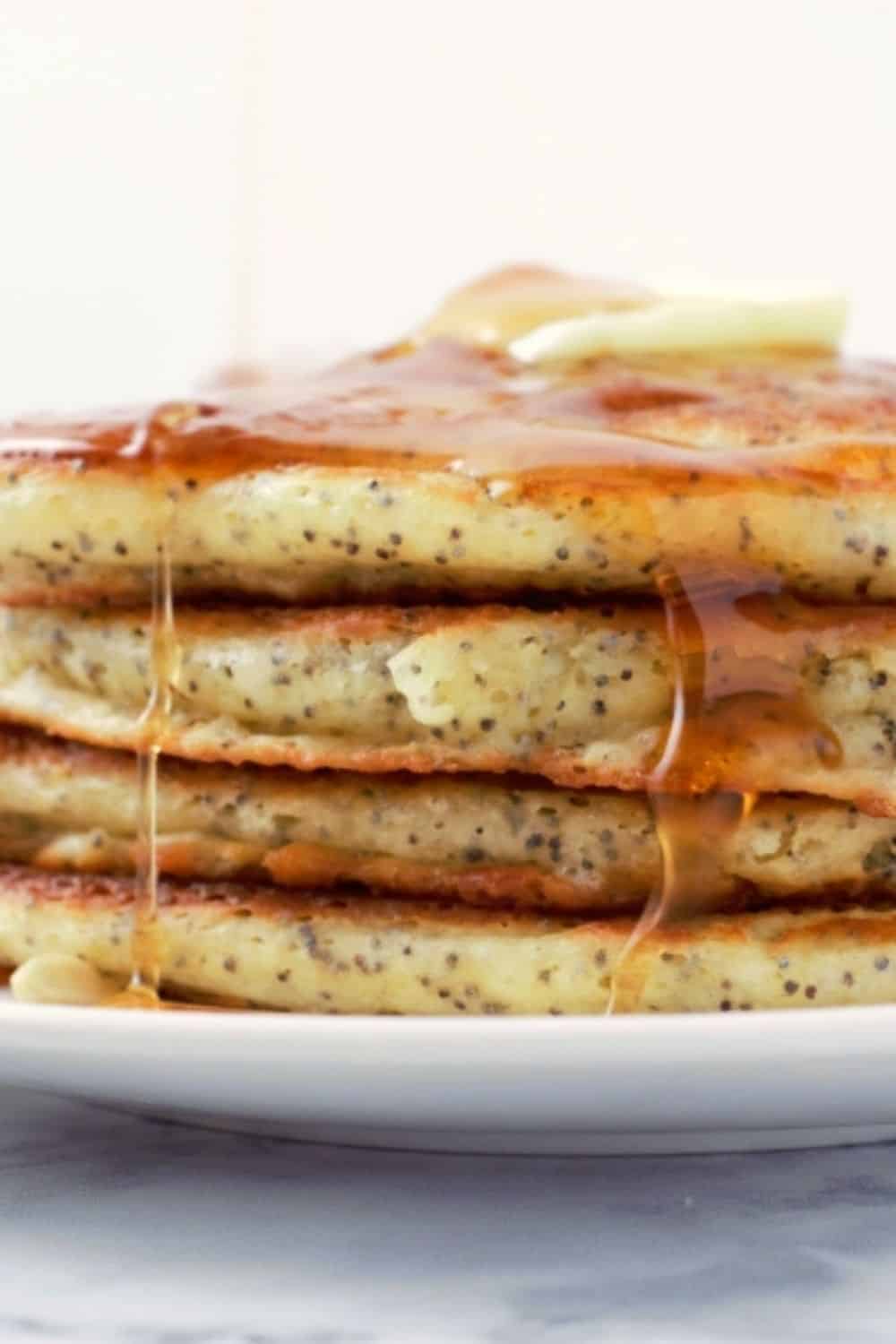 Lemon Poppy Seed Pancakes in a stack on a plate.
